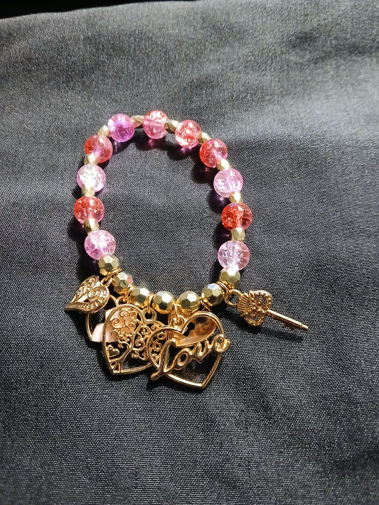Handmade red, pink, clear and gold bracelet with gold heart, love and key charms.