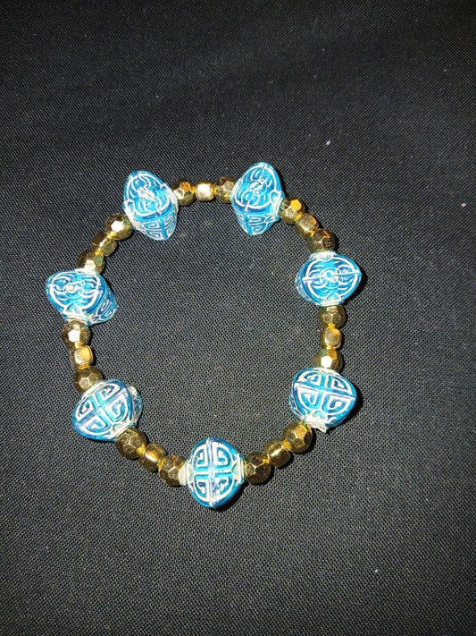 Handmade geometric shipped blue and gold beads, and gold spacer beads.