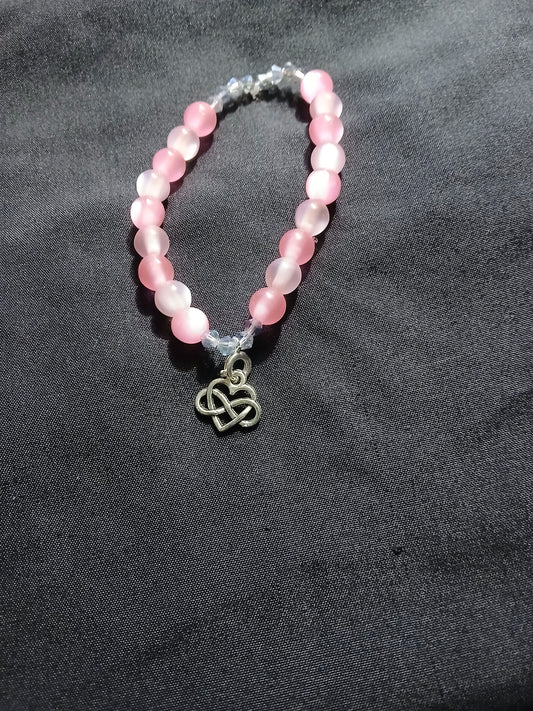 Handmade pink and clear bracelet with heart infinity symbol charm.